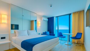 Una camera d'albergo moderna con un letto grande, una scrivania e una sedia.