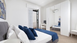 A modern bedroom with a bed, bedside table, and a desk.