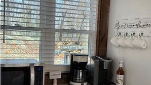 A kitchen with a microwave, coffee maker, and a bottle of Monin syrup on the counter. - Relax near Gettysburg ski/wineries/fire pit! (Orrtanna)