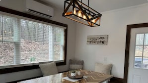 A modern kitchen with a large wooden herringbone table, a built-in bench, and a hanging light fixture. - Relax near Gettysburg ski/wineries/fire pit! (Orrtanna)