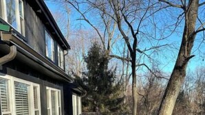 Un terrazzo in legno con posti a sedere all'aperto e una ringhiera.