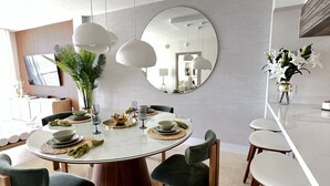 A modern dining area with a round table, chairs, and pendant lights. - Chic Penthouse  in the heart of Miami amazing Ocean and Sunset view (Miami)