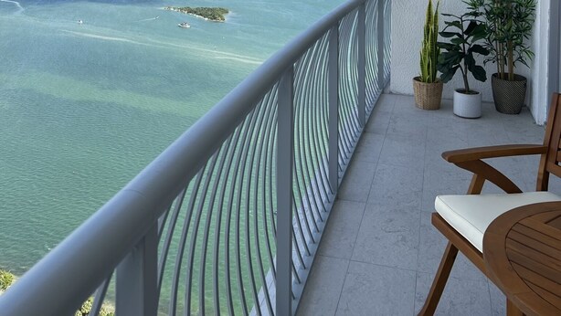 A balcony with a view of a coastal city, a railing, and potted plants. - Chic Penthouse  in the heart of Miami amazing Ocean and Sunset view (Miami)