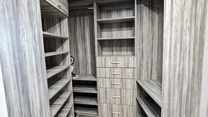 A walk-in closet with wooden shelving and drawers, featuring a herringbone-patterned floor. - Chic Penthouse  in the heart of Miami amazing Ocean and Sunset view (Miami)