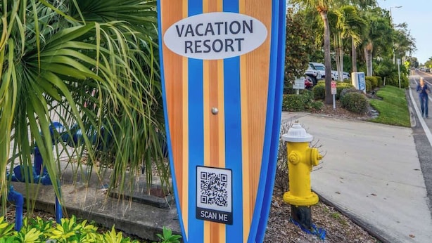 A sign for Four Shores Vacation Resort with a QR code.