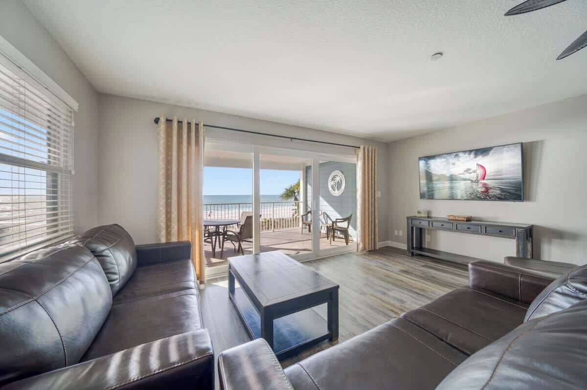 A modern living room with a sofa, coffee table, and a TV mounted on the wall.