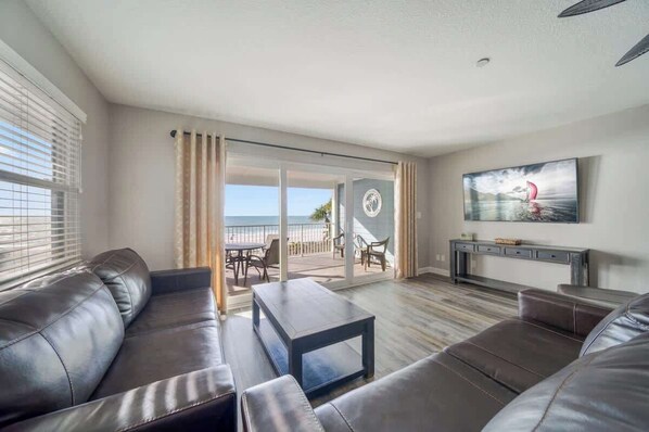A modern living room with a sofa, coffee table, and a TV mounted on the wall.