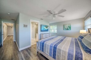 A bedroom with a bed, a ceiling fan, a door, and a window. - Four Shores #3 Gulf Condo Direct Gulf w Pool & Spa (Indian Shores)