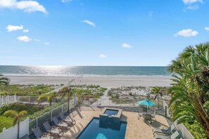 A pool area with lounge chairs and a view of the beach. - Four Shores #3 Gulf Condo Direct Gulf w Pool & Spa (Indian Shores)