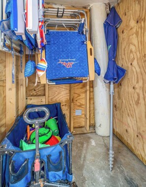 Un espace de rangement avec un tapis bleu, une bouteille d’eau verte et un sac bleu.