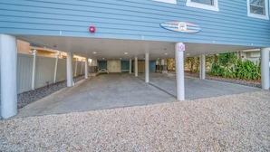 A building with a covered parking area, a sign indicating a swimming pool, and a gated entrance. - Four Shores #2 Sunset Condo Direct Gulf w Pool&Spa (Indian Shores)
