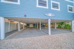 A building with a covered parking area, a sign indicating a swimming pool, and a gated entrance. - Four Shores #2 Sunset Condo Direct Gulf w Pool&Spa (Indian Shores)