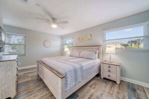 A bedroom with a bed, a nightstand, a dresser, and a ceiling fan. - 2000 SqFt Condo with Private Indoor Poolside Cabana (Indian Shores)