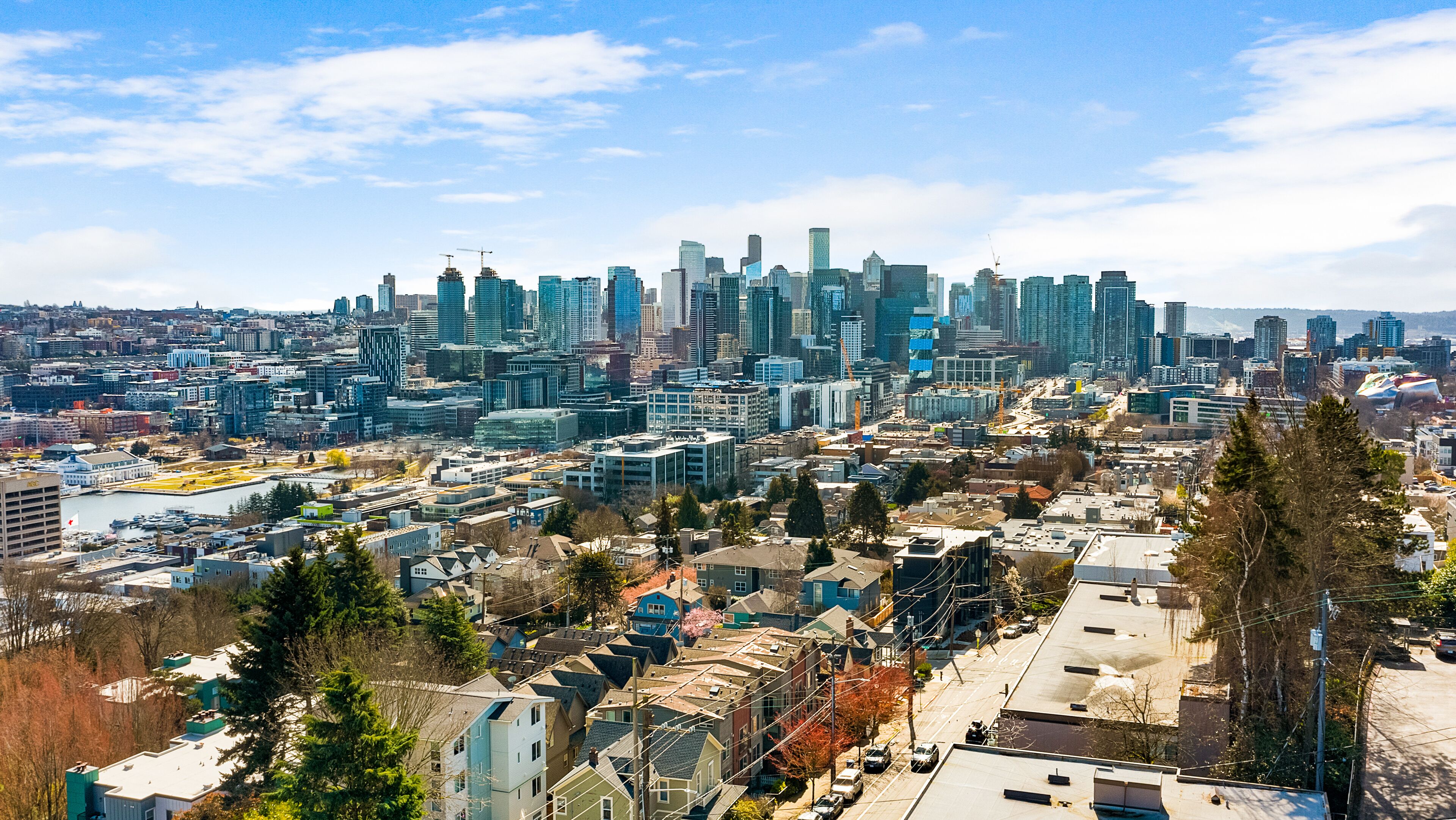 A cityscape with high-rise buildings, a marina, and residential areas.