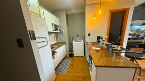 A compact kitchen with a central island, a microwave, and a sink. - Saint Sebastian Flat 601Duplex no Centro (Jaragua do Sul)