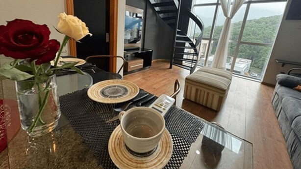 A modern living room with a dining area, a staircase, and a view of the outdoors. - Saint Sebastian Flat 601Duplex no Centro (Jaragua do Sul)