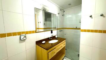 Un baño con lavamanos, espejo y ducha.