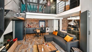 A modern loft apartment with a kitchen, dining area, and living room.