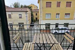 A balcony with wooden benches, a white car parked in front, and buildings with balconies and windows in the background. - SE045 - Senigallia, three-room apartment convenient to services (Senigallia)