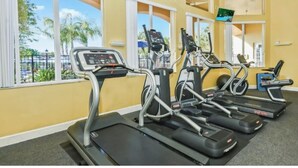 A gym with treadmills, exercise bikes, and a TV screen. - Private patio and hot tub in Terra Verde Resort (Kissimmee)