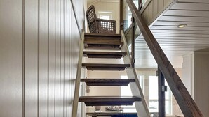 A wooden staircase with a glass railing, leading to an upper floor. - Nice home in Rysstad with WiFi (Rysstad)