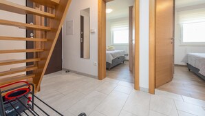 Une chambre moderne avec un escalier en bois, un lit et une fenêtre.
