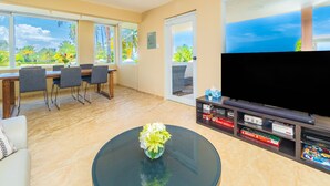 Una sala de estar con comedor, televisor y estantería.