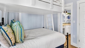 A bunk bed with a white headboard, a ladder, and a white door to the right. - Palm Tree Retreat TC 3102 (Port Aransas)