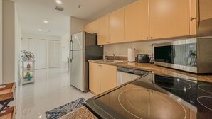 A modern kitchen with stainless steel appliances, wooden cabinets, and a granite countertop. - Beautiful 2BE/2BA Renovated Apt in Coral Gables (Miami)