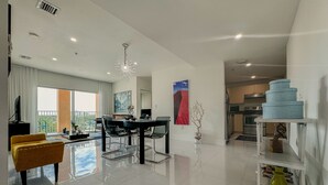 A modern living room with a dining area, a kitchen, and a balcony with a view. - Beautiful 2BE/2BA Renovated Apt in Coral Gables (Miami)