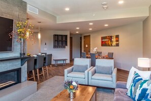 Cozy living space with a fireplace, flat-screen TV, dining area, and comfortable seating.