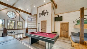 A pool table in a room with wooden walls and a ceiling with exposed beams. - Two King Suites, Bunk Loft with Games, Hot Tub (Broken Bow)