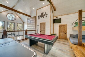A pool table in a room with wooden walls and a ceiling with exposed beams. - Two King Suites, Bunk Loft with Games, Hot Tub (Broken Bow)