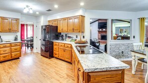 Una cocina amplia con armarios de madera, encimera de granito y una isla integrada.