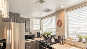 A modern kitchen with stainless steel appliances, granite countertops, and large windows with blinds. - The Stay at Six•One•Four / Walk right out to Route 66 (Williams)