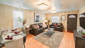 A living room with a sofa, coffee table, and dining area set up with plates and glasses. - The Stay at Six•One•Four / Walk right out to Route 66 (Williams)