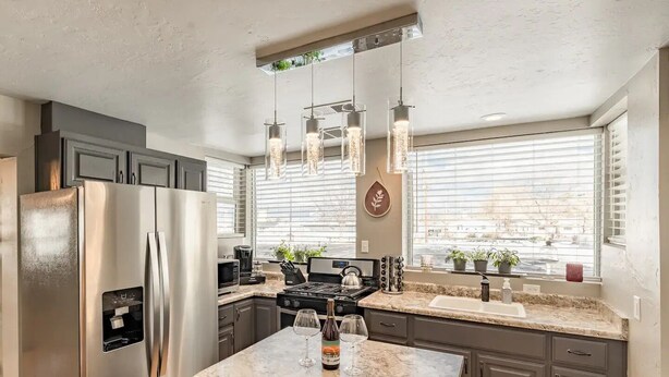 A modern kitchen with stainless steel appliances, granite countertops, and pendant lighting. - The Stay at Six•One•Four / Walk right out to Route 66 (Williams)