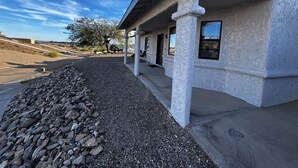 A building with a covered porch, stone columns, and a gravel pathway. - Lake Havasu Oasis: 3BR, Pool, Hot Tub, Game Room & Boat Parking (Lake Havasu City)
