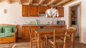 A cozy kitchen with wooden cabinets, a dining table, and chairs.