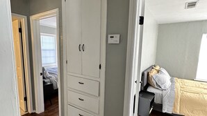 A bedroom with a bed, a wardrobe, and a nightstand.