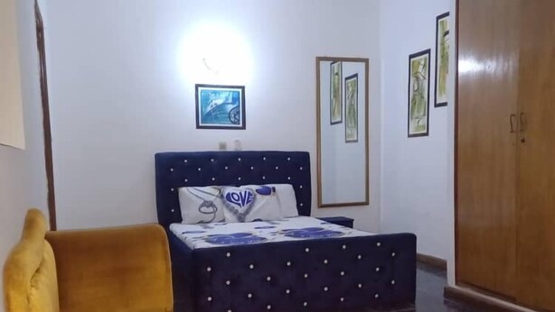 A bedroom with a bed, a wardrobe, and a sofa. - Hotel Résidence Georges Colette Abidjan  (Abidjan)
