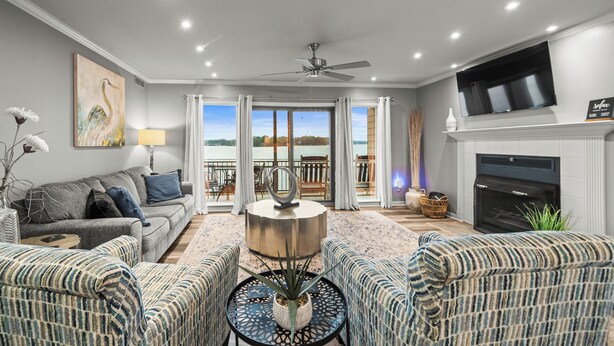 A modern living room with a grey sofa, patterned armchairs, a round coffee table, and a fireplace. - Cozy Lakefront Condo, 2BR/2BA Retreat (Hot Springs)