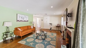 A living room with a sofa, coffee table, and a painting on the wall. - Modern Relaxing Retreat With Private Pool 4 Bedroom Home by RedAwning (Azusa)