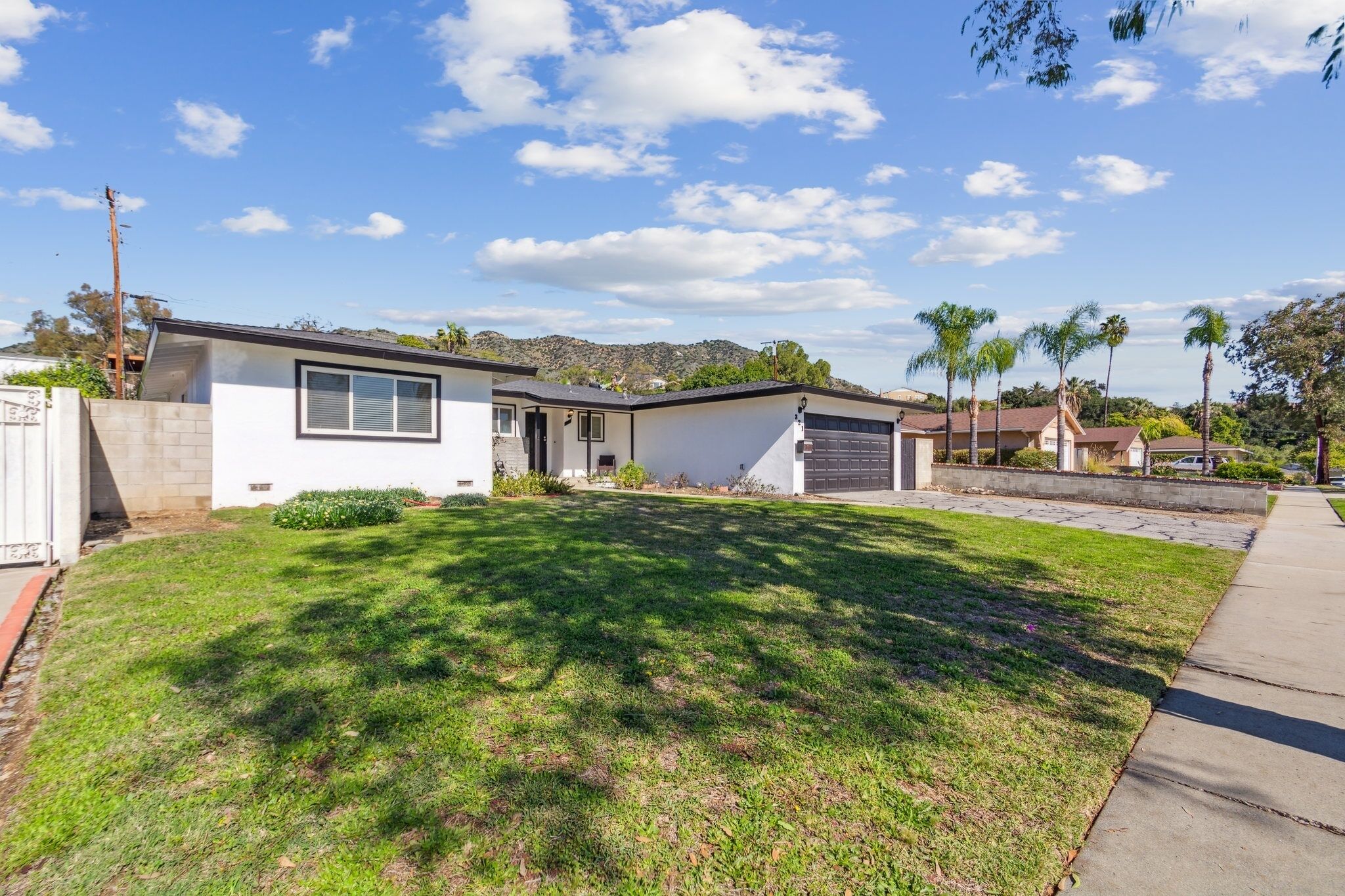 A single-story house with a garage, a front lawn, and a clear sky.