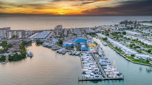 A marina with boats docked, a large building with a blue roof, and a sunset over the water. - San Marco 5th Floor With Private Beach (Venice)
