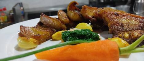 Un plato de comida con carne, patatas y verduras.