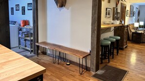 A room with a wooden bench, a deer head mounted on the wall, and a bar area with stools. - Outdoorsman's Paradise Sleeps 9 in Cedar (Cedar)