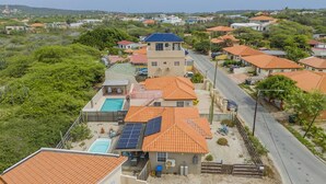 Ein Wohngebiet mit Häusern, die rote Ziegeldächer, einen Swimmingpool und Solaranlagen haben.