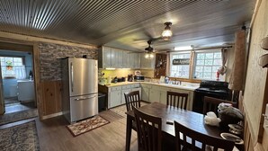 A compact kitchen with a refrigerator, stove, and dining table.