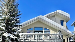 A two-story house with a garage, a balcony, and snow-covered trees. - Steamboat in Style! Dog Friendly, Walk to Resort, Hot Tub, Great Views, Locker (Steamboat Springs)